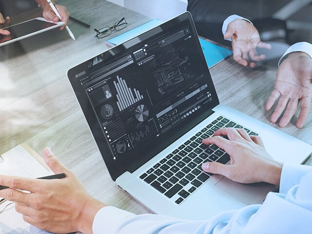 People reviewing financial services data on a computer