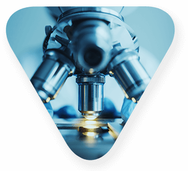 Close up of a microscope lens positioned over a slide