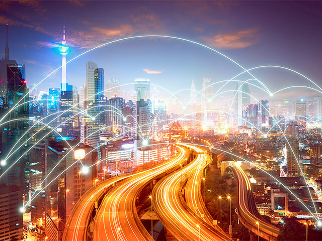 City with arcs of light between points connecting cloud and data analytics from building to building