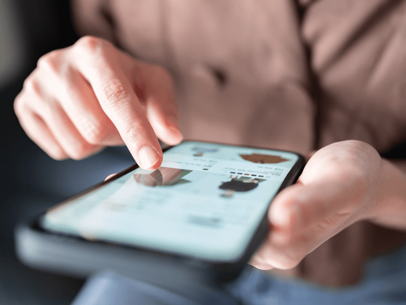 customer engaging with digital experience on their personal phone. Only hands, and phone screen are visible, in focus.