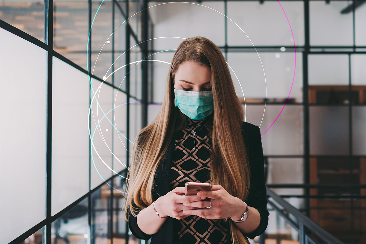 woman wearing mask while looking at phone