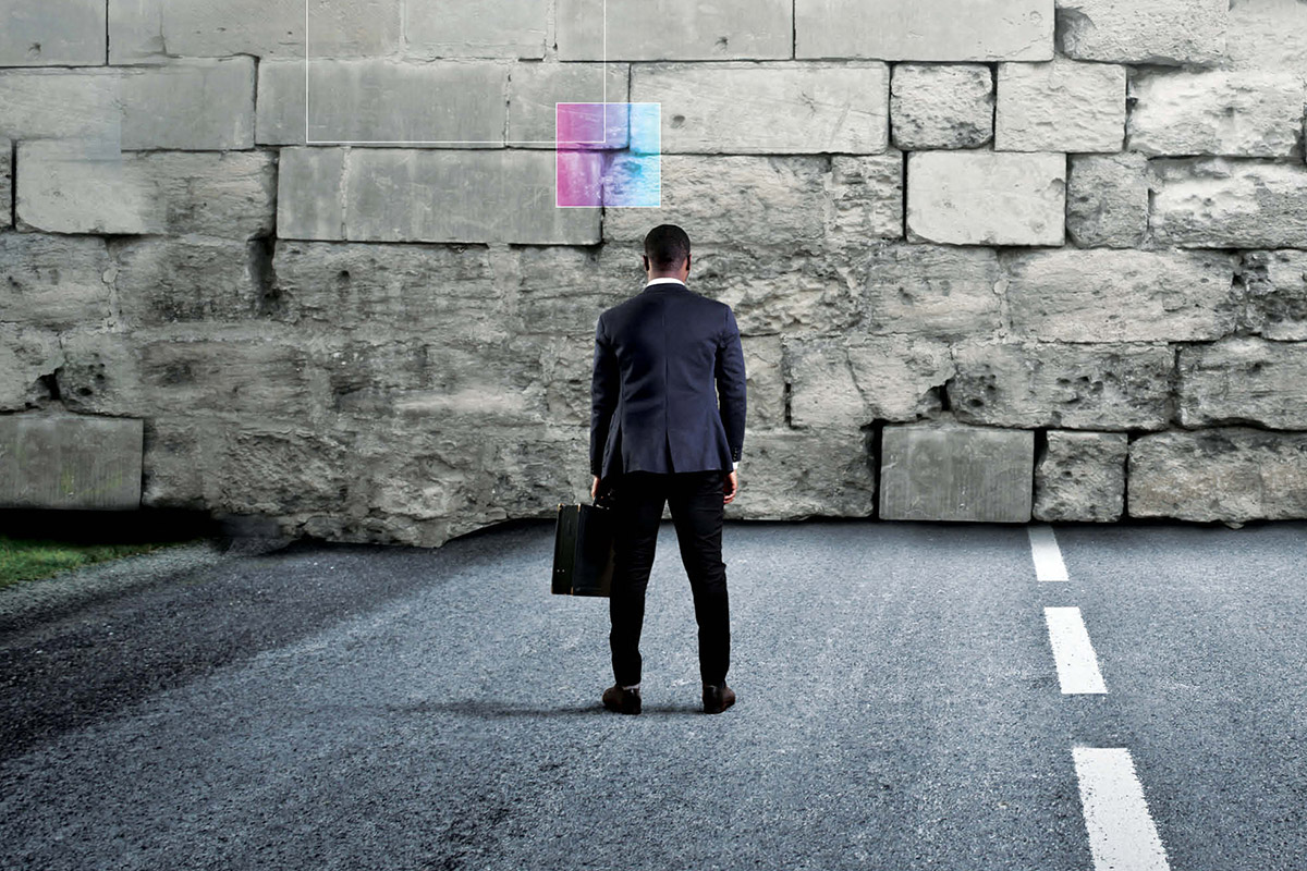 man with briefcase looking at a wall with no way ahead