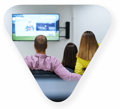 three individuals watching television together
