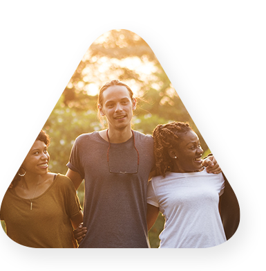 group of individuals laughing and smiling outside while embracing one another.