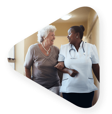 Elderly woman being helped down the hall in assisted living.