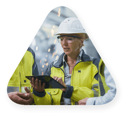 woman in hard hat reviewing data on tablet with two other workers