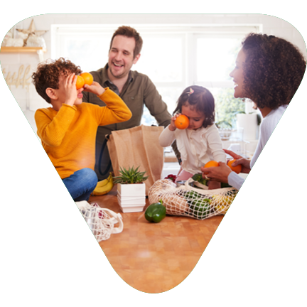 Triangle with a family in the kitchen having fun unloading the groceries