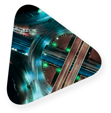 A traffic circle from above with a long exposure so the cars appear as streams of light