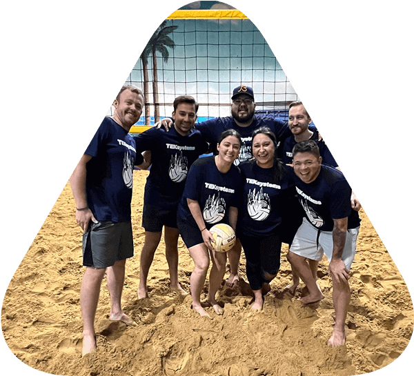 Triangle containing image of TEKsystems employees playing beach volleyball