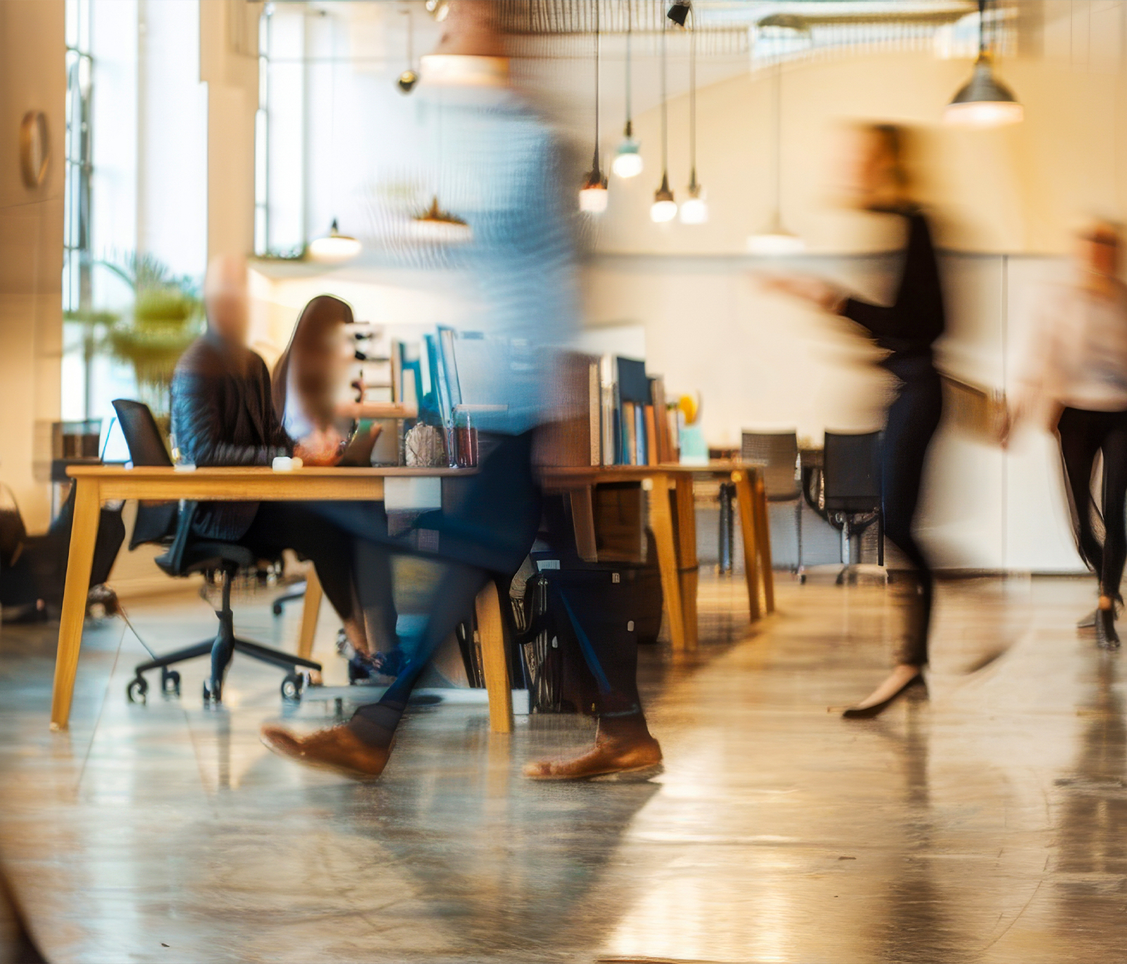 A busy office with people working at desks and walking around
