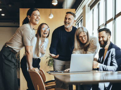 group of people in an office round a laptop
