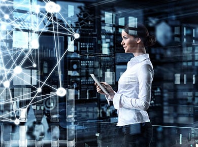 A woman breaking into IT post-COVID-19 stands holding a tablet in front of a holographic web of data