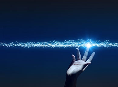 A hand reaches up to touch the bright lights of data streams on a blue background