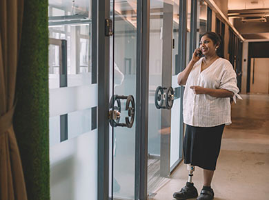 Businesswomen walking down the corridor talking on the phone
