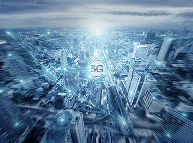 A circle with 5G written in it overlaid on a blue image of light points connecting across a city to highlight the impact of 5G on the recruitment industry