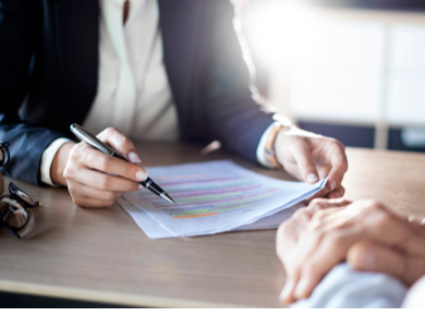 two people at a desk reviewing document