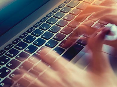 A pair of hands fly over a laptop keyboard as someone uses LinkedIn to its full potential