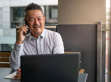 A man on a phone interview sits at his computer