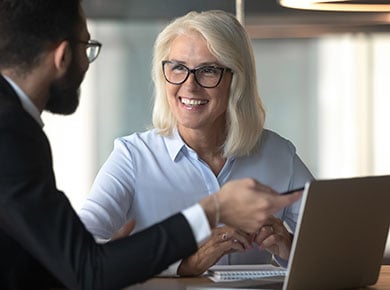 Two people discussing something using a laptop