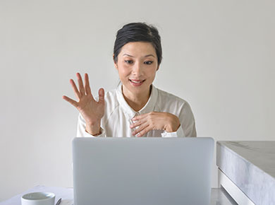 Person waving to the camera on a video call.