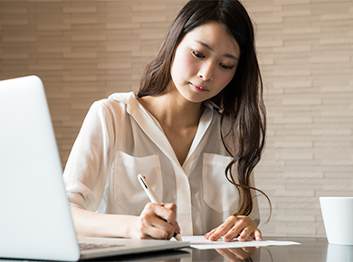 Lady writing with laptop