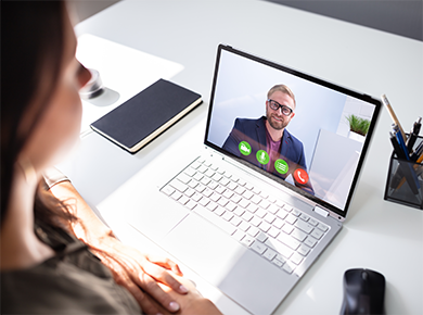 A man interviewing on video on a woman's laptop screen