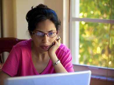 A woman sitting at her computer takes opportunities for upskilling