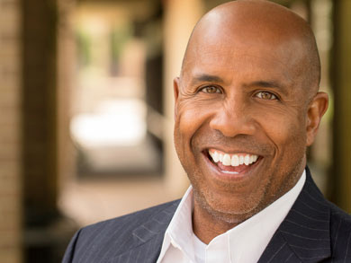 man in a navy stiped suit smiling