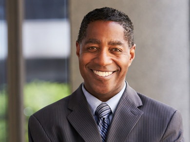 executive man smiles in a gray suit