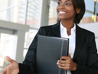professionally dressed woman reaches for a handshake during an interview