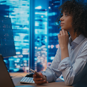 Person seated at a desk looking at large digital data displays.