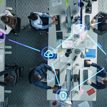 Office overhead view with network icons for cloud, Wi-Fi, and security.