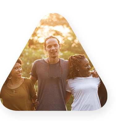 group of individuals laughing and smiling outside while embracing one another.
