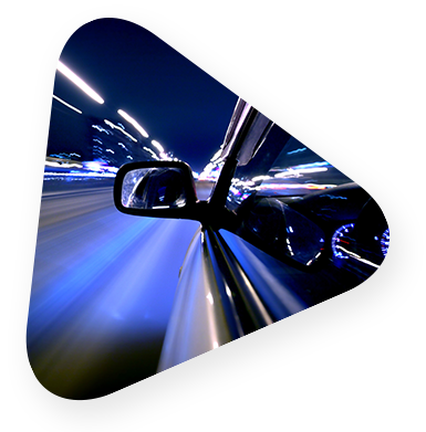 A sideview mirror on a car driving down the highway at night