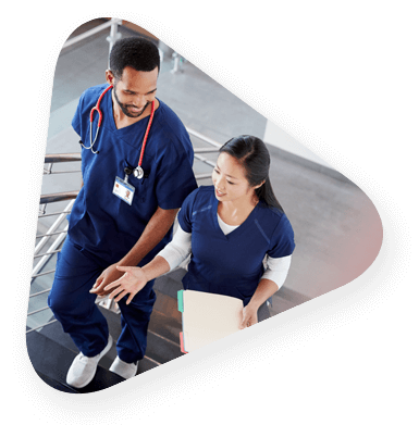 two members of hospital staff discussing data as they walk through the hospital.