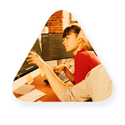 A woman and a man reviewing some code on the computer