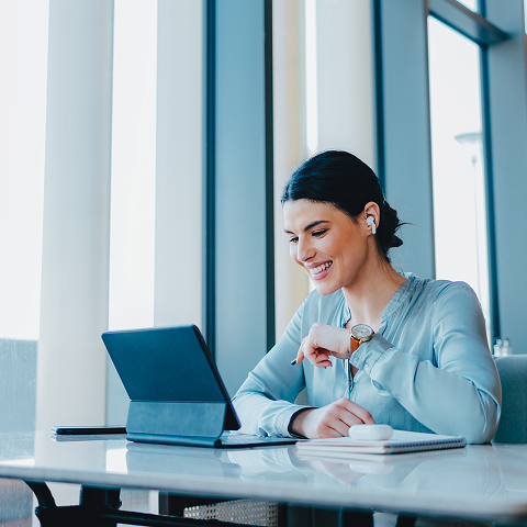 woman in business dress using a table to take a video call