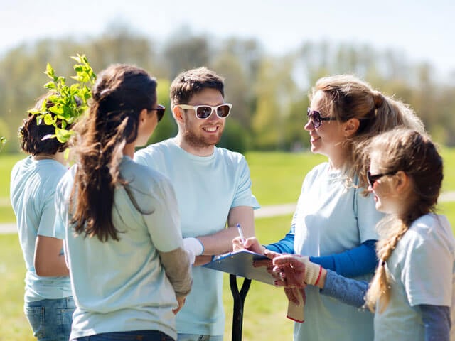 5 people doing community volunteer work in a field