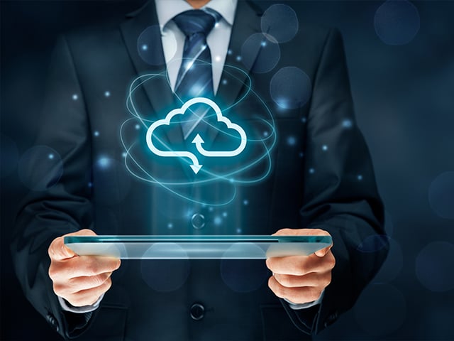man in a suit reviewing cloud analytics on a tablet