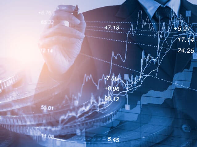Person holding pen with overlay of financial data