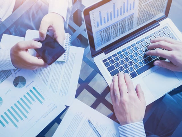 Person on laptop studying charts based on data from Salesforce Sales and Service Clouds