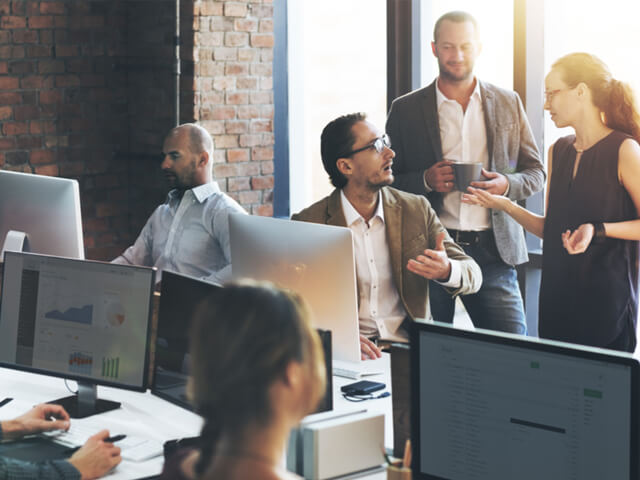 a digital team of product owner, content strategist, design and developer casually meet in person