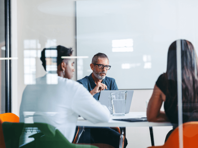 three young professionals reviewing canidates in a modern style conference room