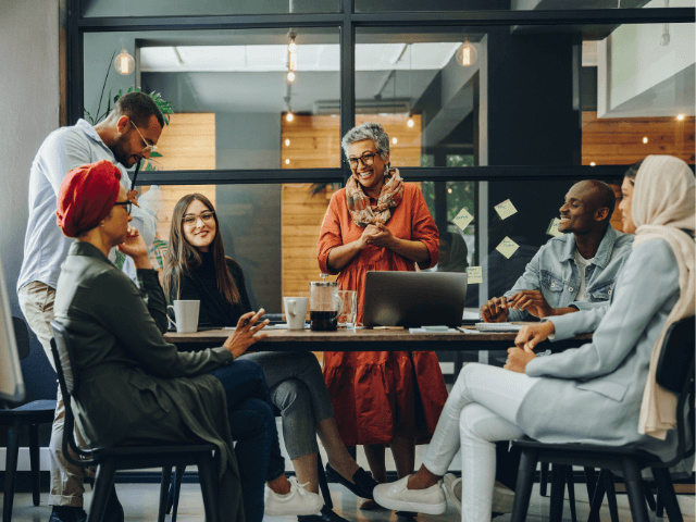 A diverse group of professionals gathered in a fishbowl style conference room