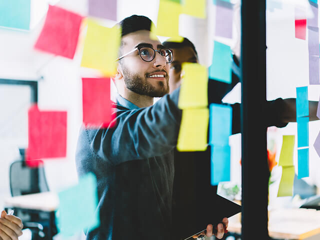 two collegaues using sticky notes to strategize and brainstorm together