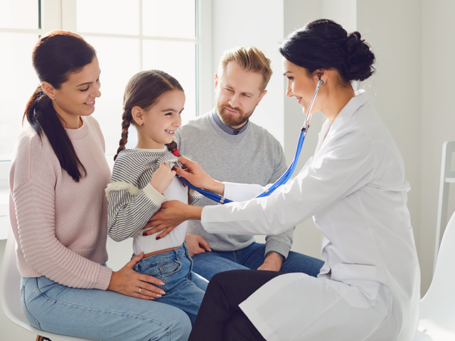 A doctor with a young patient and family