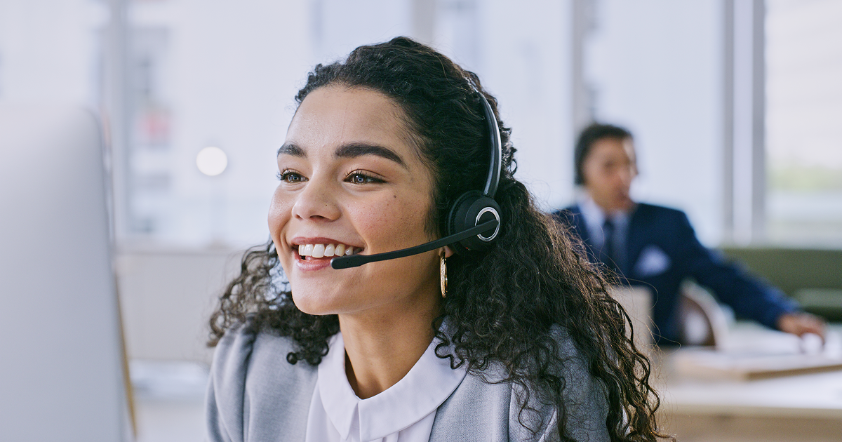 Customer service representative wearing a headset at a computer