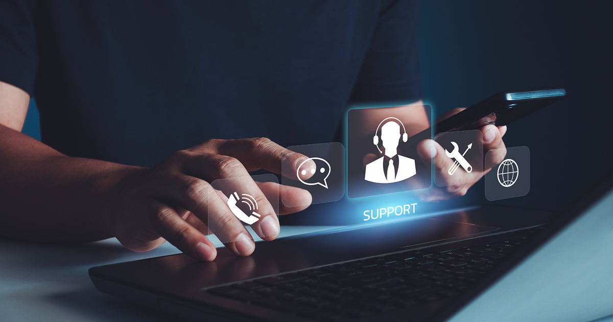 Person using a laptop with virtual customer support icons displayed.