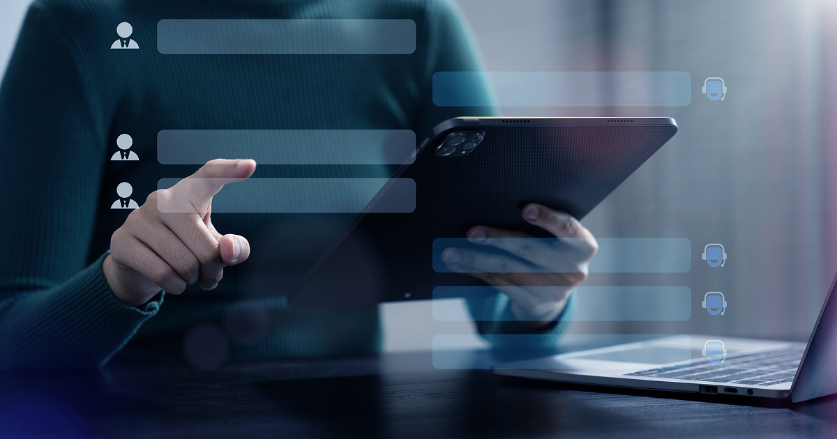 Person using a tablet and laptop with floating digital interface elements on screen