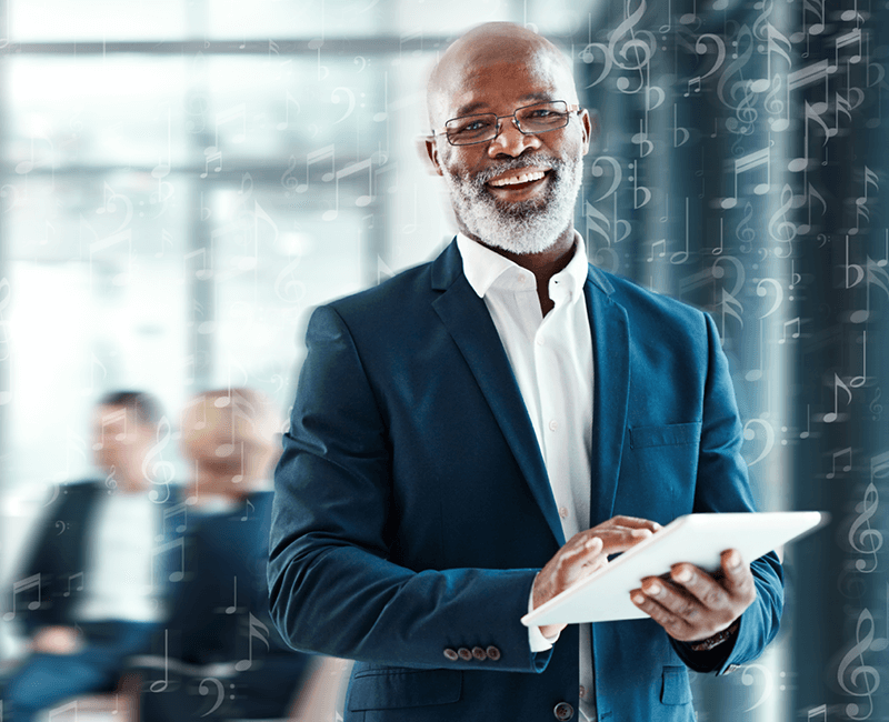 Business professional holding a table smiling at camera. White music notes overlay